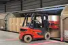 Forklift transporting large paper rolls for rail transport