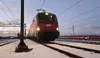 Rote ÖBB Vectron-Elektrolok im verschneiten Rangierbahnhof bei Dämmerung, mit Scheinwerfern.