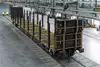 Leerer Rundholzwagen für den Holztransport in einer Werkshalle, mit senkrechten Rungen für Stammholz.
