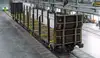 Leerer Rundholzwagen für den Holztransport in einer Werkshalle, mit senkrechten Rungen für Stammholz.