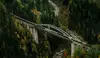 Güterzug überquert Brücke in einem Tal
