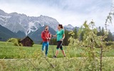 2 Wanderer mit einer Holzhütte im Hintergrund