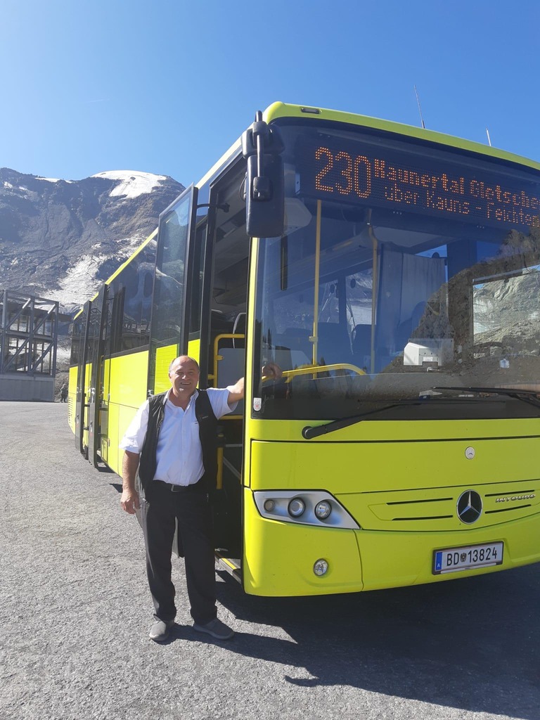 Postbus Lenker steht neben seinem Bus vor schönem Bergpanorama © ÖBB Kapferer Postbus Lenker steht neben seinem Bus vor schönem Bergpanorama