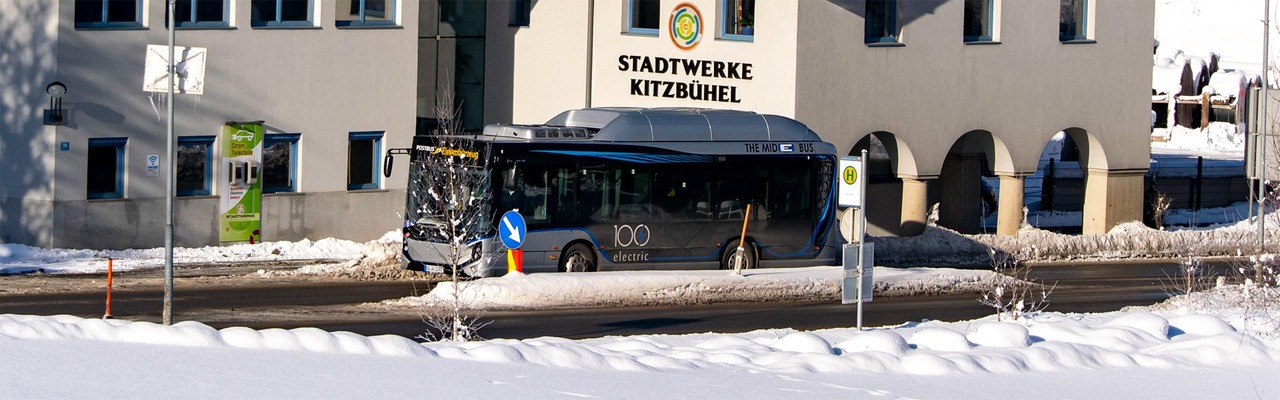 Elektro-Bus fährt durch winterliches Kitzbühel