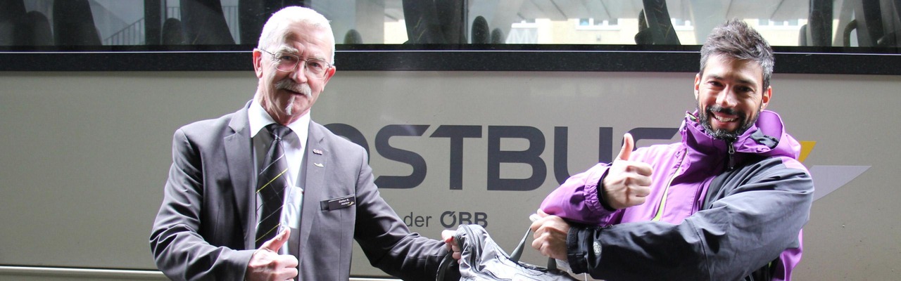 Postbus Mitarbeiter übergibt verlorenen Rucksack an Kunden