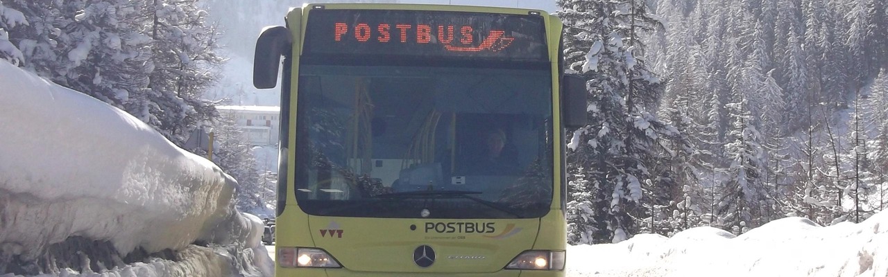 Postbus unterwegs in Winterlandschaft