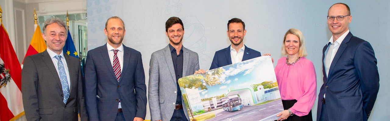 Vorstand und Politiker zeigen Bild eines Wasserstoffbusses