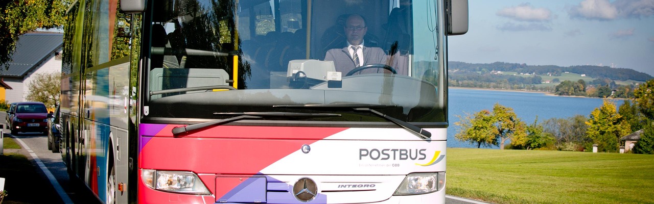Postbus unterwegs auf der Straße