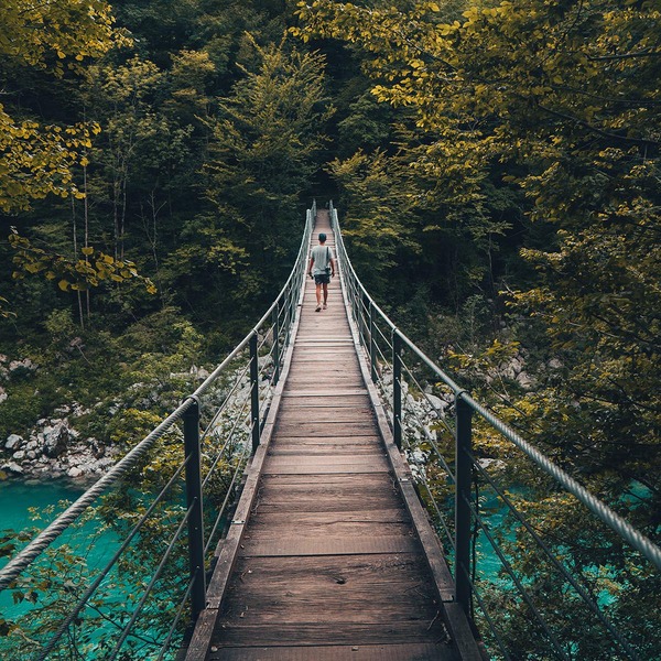 Ein Mann überquert eine kleine Holzbrücke