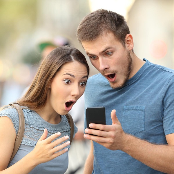 Paar blickt erschreckt auf Smartphone