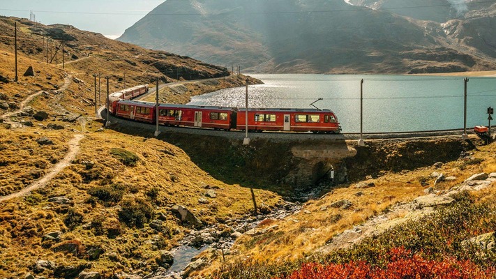 Zug fährt entlang eines Sees