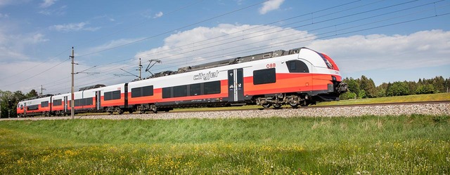 Cityjet fährt durch grüne Landschaft