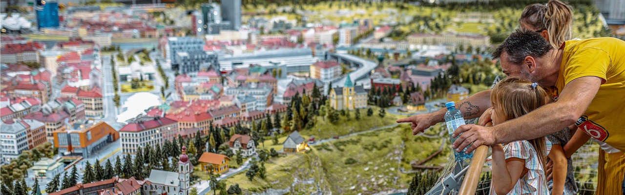 Mother and child stand in front of model trains