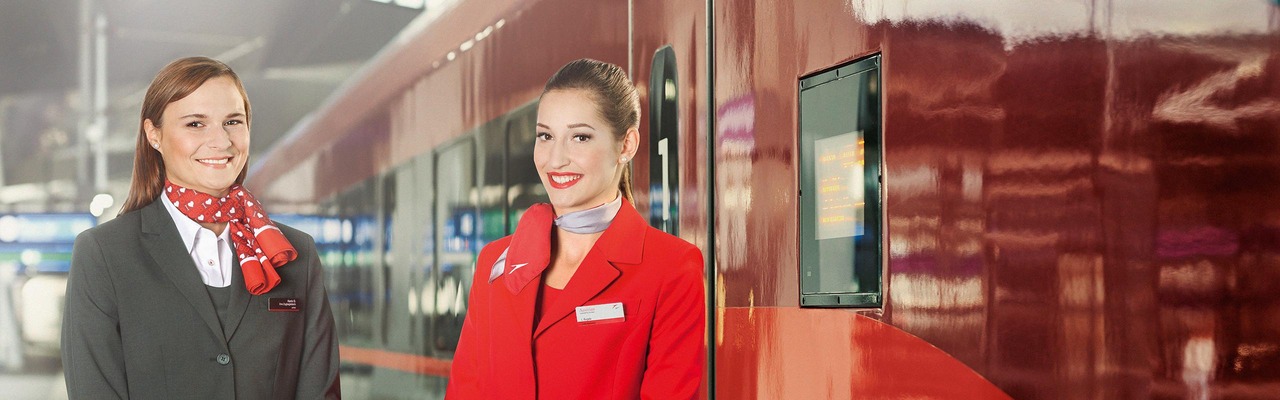 ÖBB Zugbegleiterin und Austrian Airlines Stewardess vor Railjet