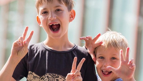 Zwei Kinder zeigen das "Peace" Zeichen mit ihren Händen