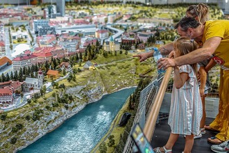 Mother and child stand in front of model trains