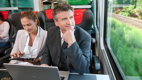 Business travelers in the ÖBB Railjet with laptop and tablet