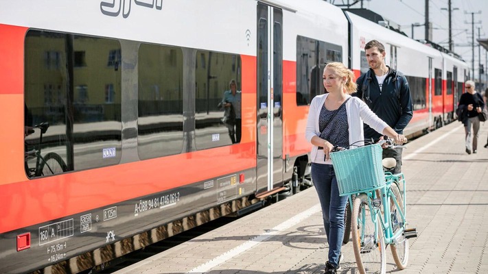 Frau mit Fahrrad am Bahnsteig
