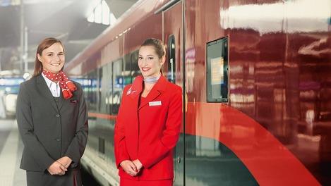 ÖBB Zugbegleiterin und Austrian Airlines Stewardess vor Railjet